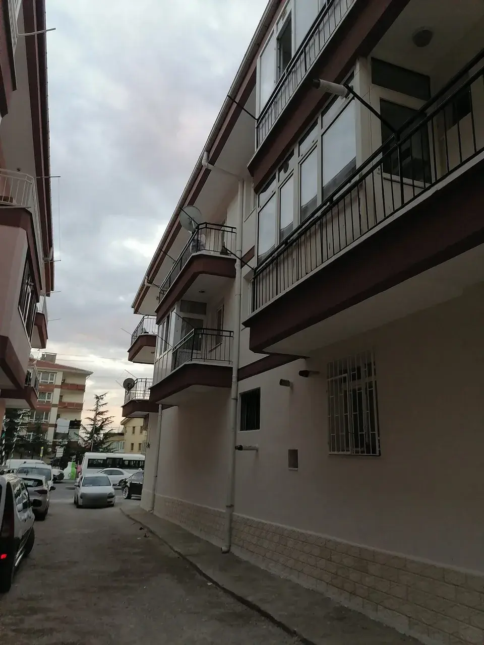 Aynı apartmanın sokak cephesi, taş desenli subasman ve kahverengi silmeler