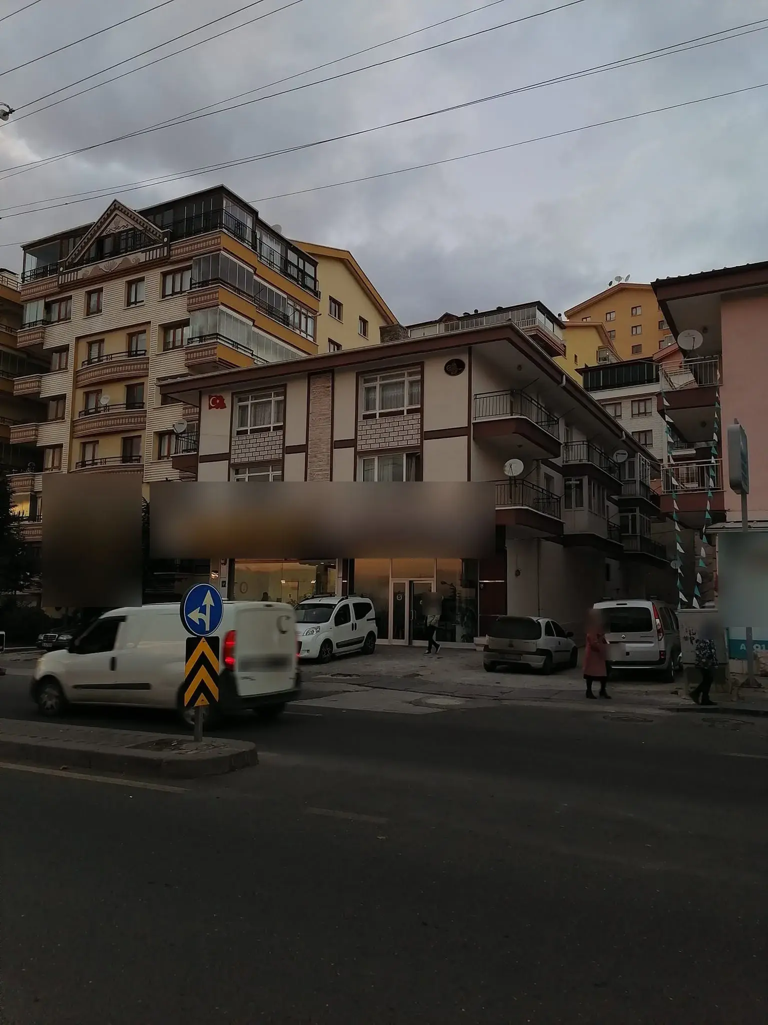 Köşe binası: krem cephe, kahverengi çerçeveler ve tuğla görünümlü paneller
