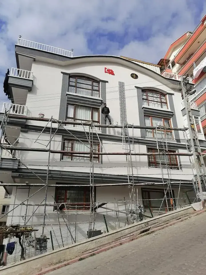 Dekoratif söveli beyaz cephe, iskele üzerinde uygulama sürüyor