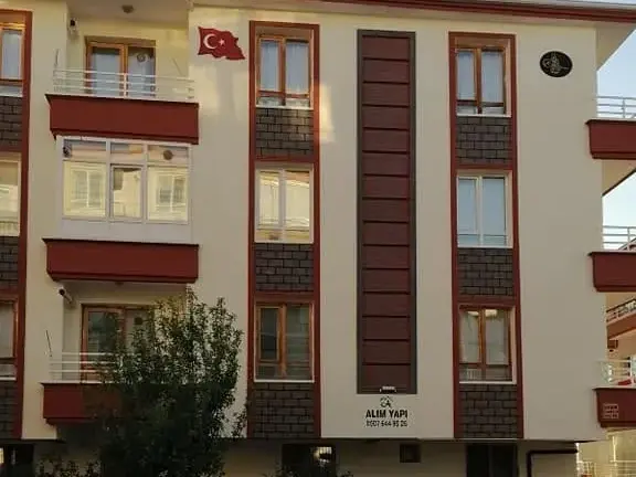 Keçiören Esertepe'de beş katlı bina, krem cephe, kahverengi dikey şerit ve tuğla desenli paneller